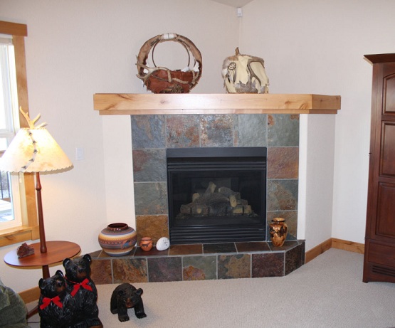 Corner fireplace design ideas with slate tile and wood shelf