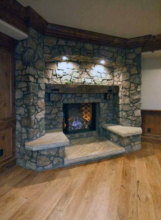 rustic stone corner fireplace design with hardwood flooring