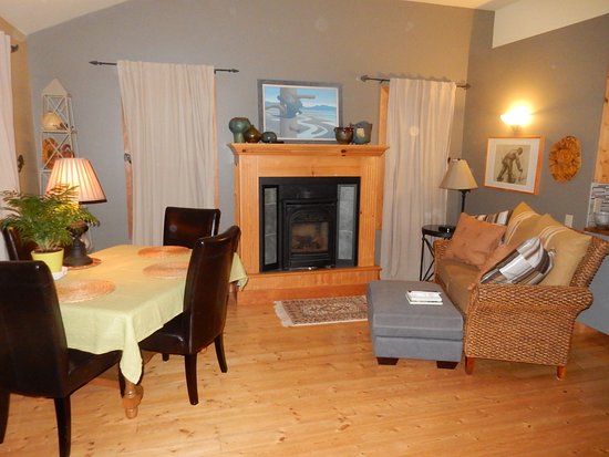 Another smaller couch by the fireplace and the dining table another smaller couch