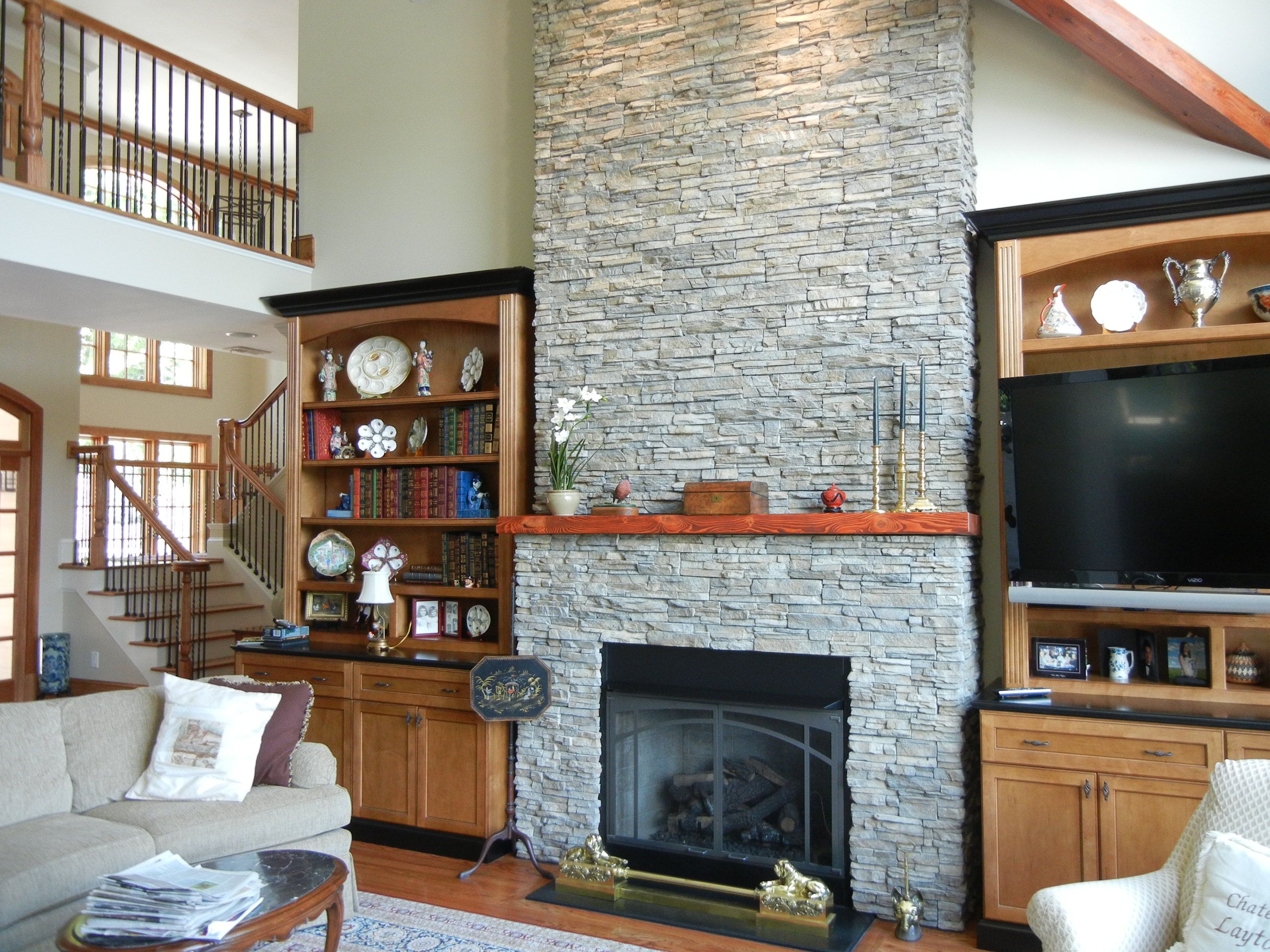 Stone fireplace surrounded by built in bookshelves creates a 0ddc d50f c5972ad1f