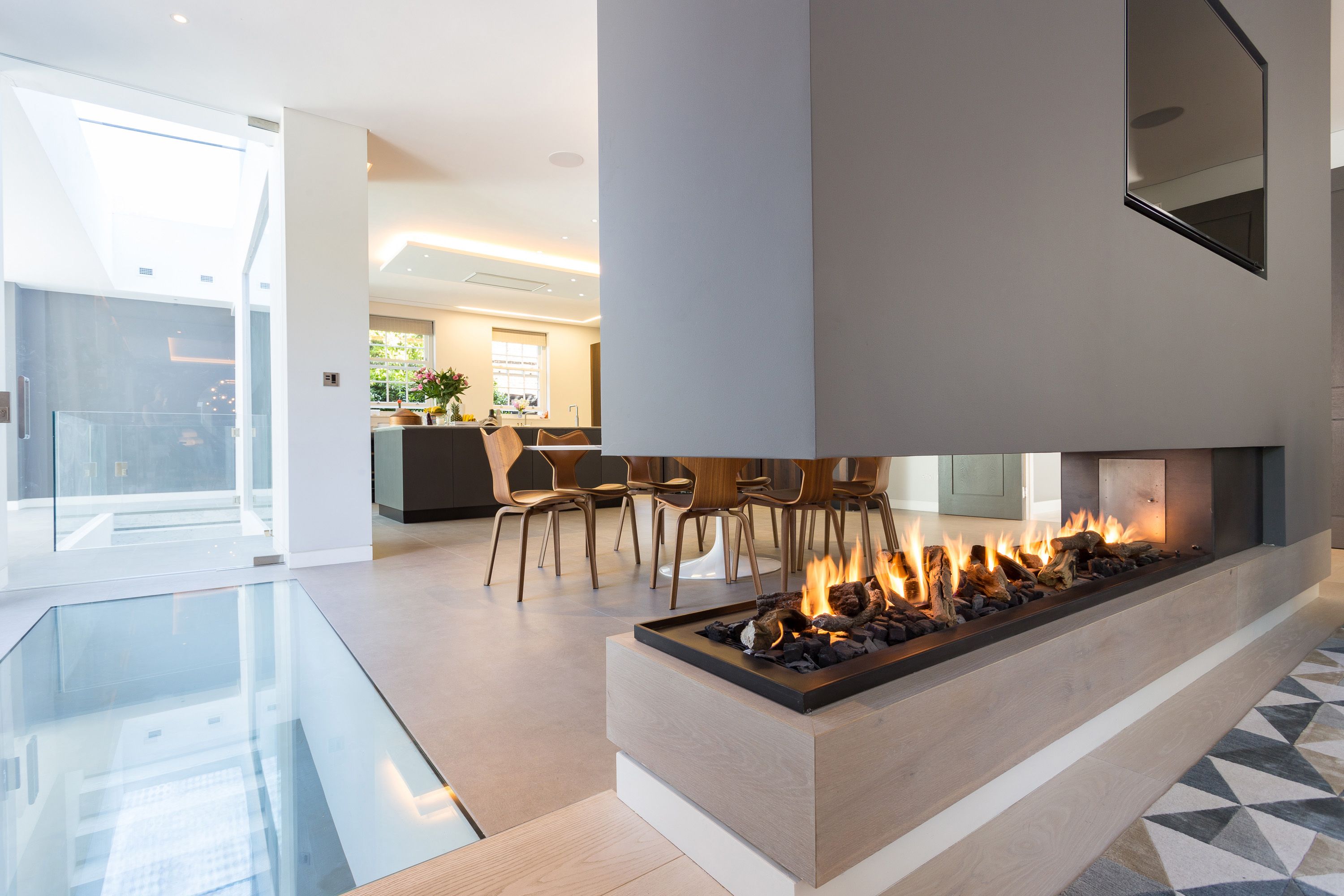 This stunning three sided gas fireplace forms part of a room 0daf f0903fbcce7f0bf348e1a