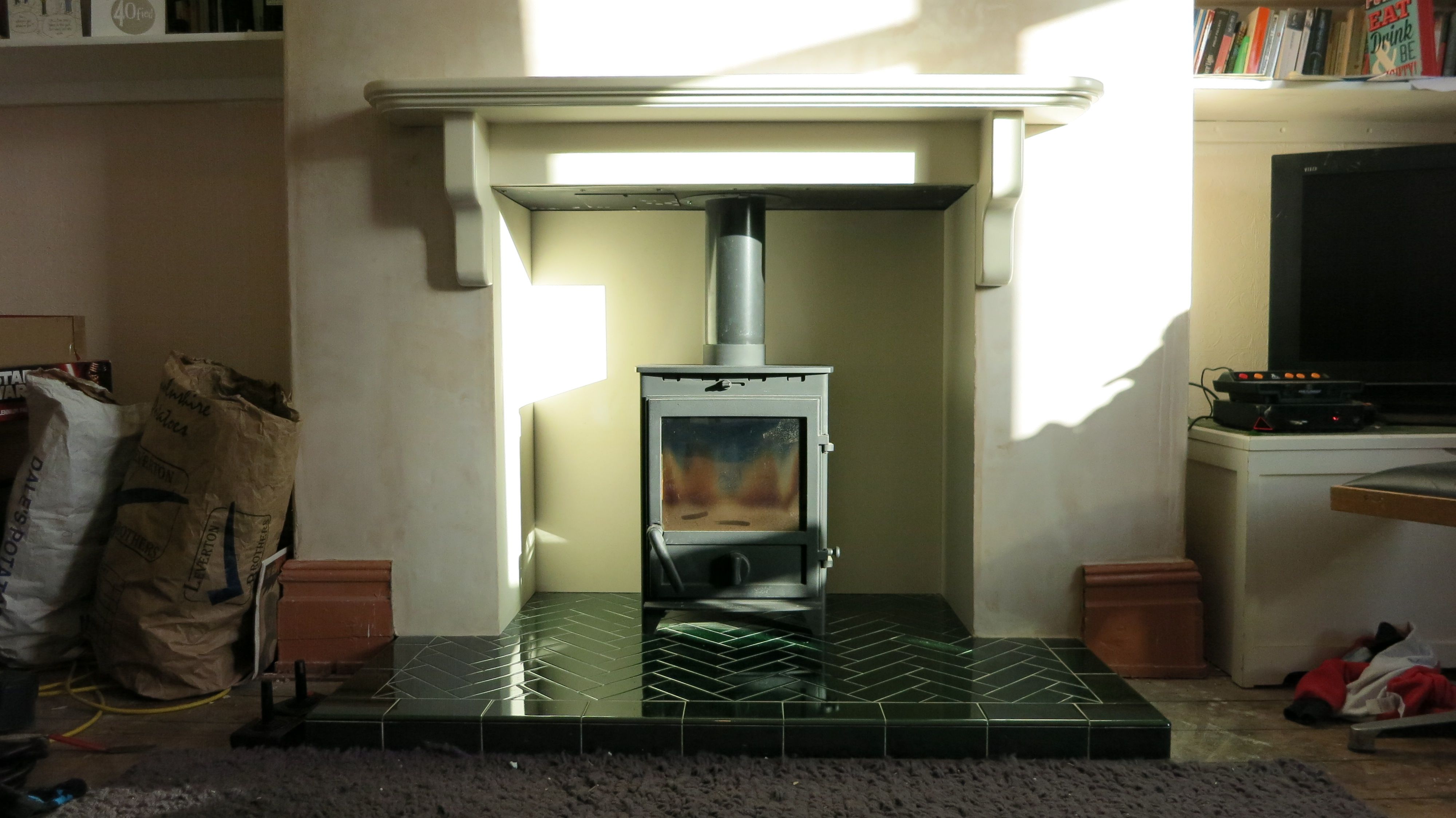 A Fireline FP5 multi fuel stove on a green herringbone tiled 0dbe82e3adc14e3e76d71e16f443ade2