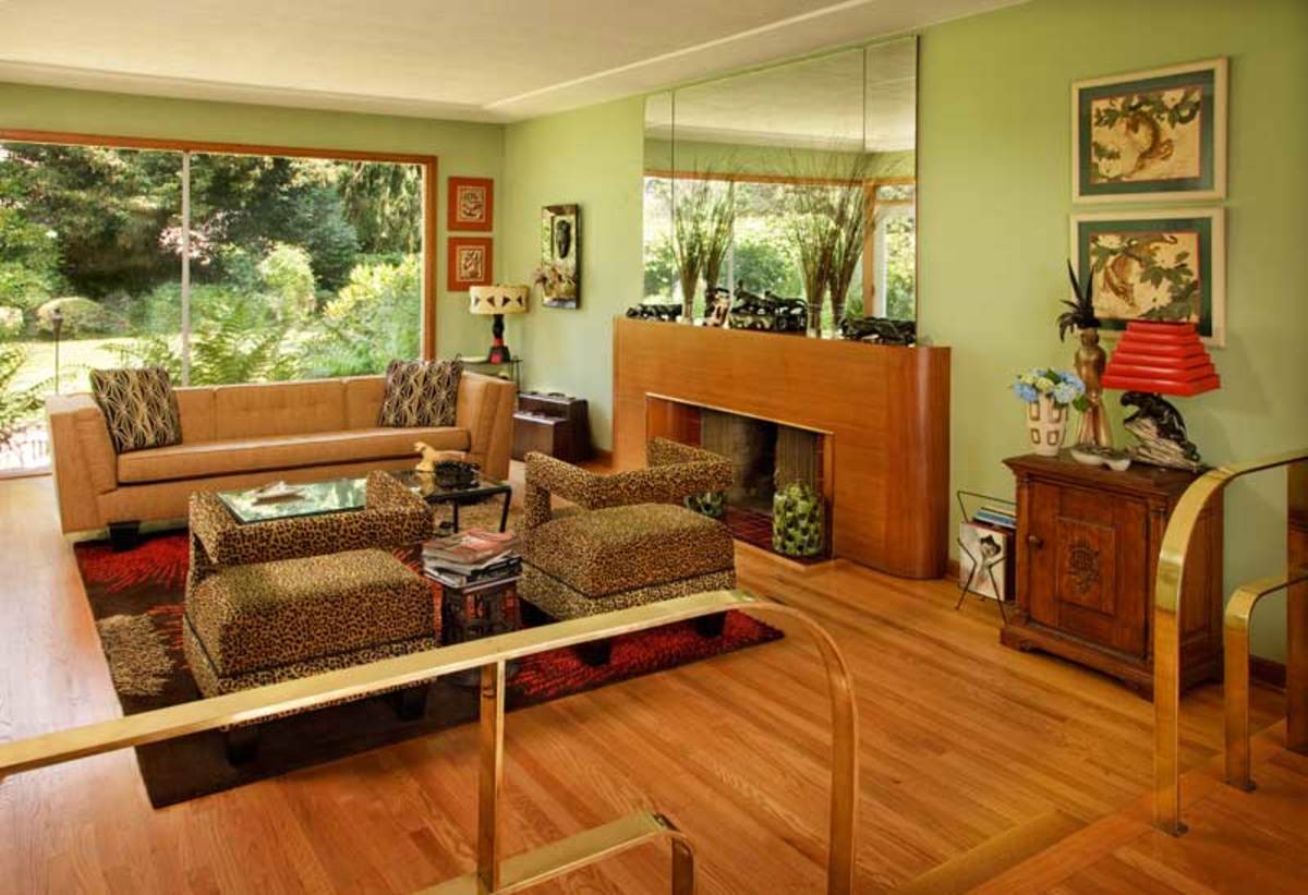 the sunken living room is trimmed in nautical style brass railings rounded like the art deco fireplace surround