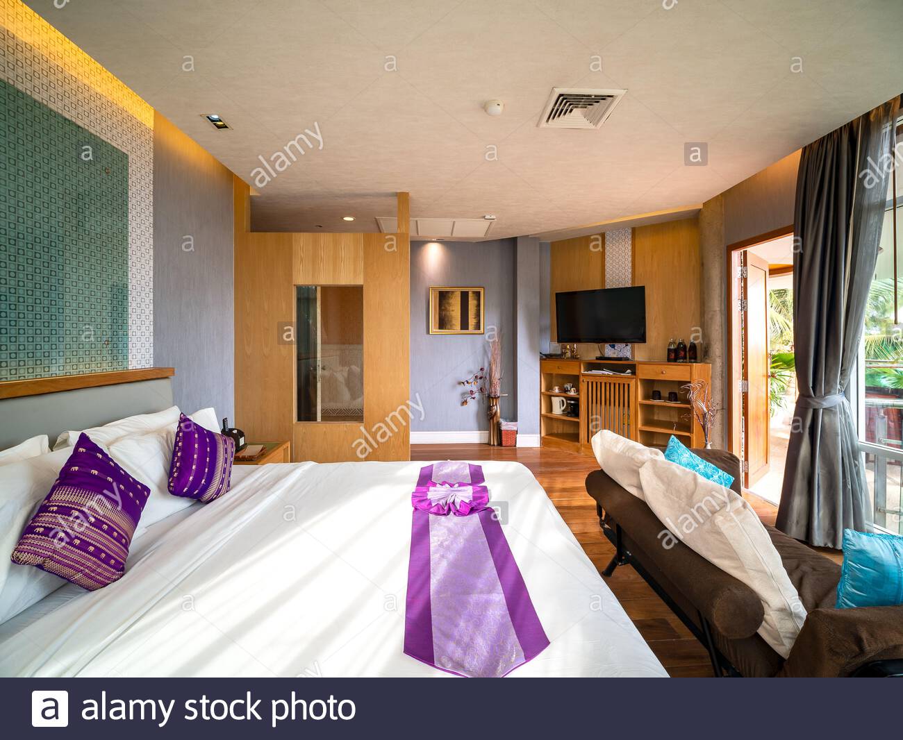 Luxury room decor with brown wooden floor and furniture in luxury room decor with brown wooden floor and furniture in warm light and window glasss for see view outside room of hotel resort in thailand 2AJRFDP