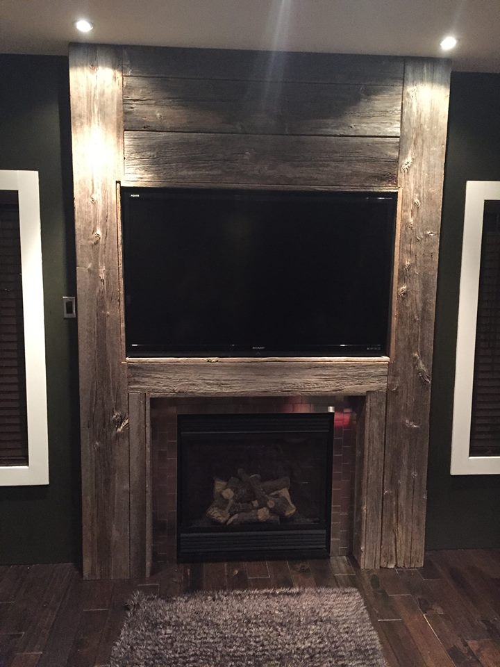 Floor to ceiling grey barnwood fireplace mantle with stainless steel tiles full