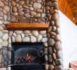 Fireplace Rocks Inspirational A Gas Fireplace Set In Colorful River Rocks with A Wooden Mantle