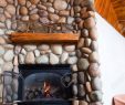 Fireplace Rocks Inspirational A Gas Fireplace Set In Colorful River Rocks with A Wooden Mantle